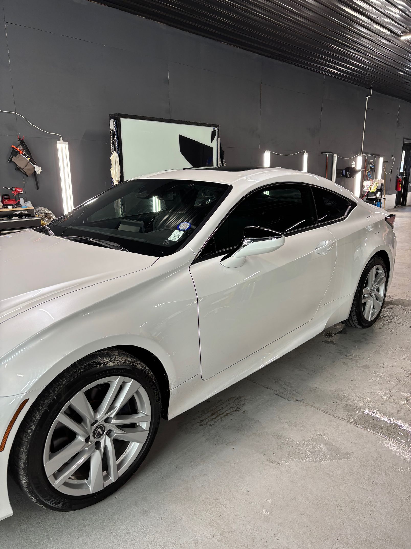 A white sports car is parked in a garage.