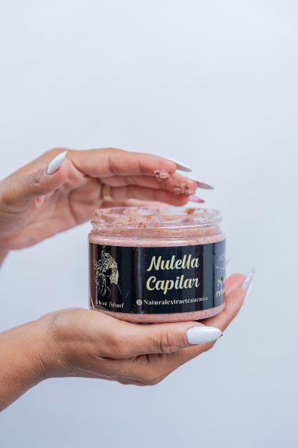 Dos manos sosteniendo un frasco de producto para el cuidado del cabello