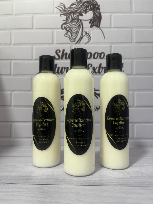 Tres botellas blancas de producto para el cabello dispuestas en fila sobre un fondo con estampado de ladrillos.