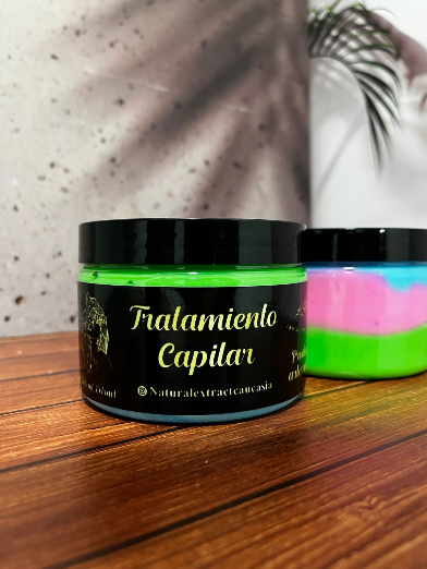 Dos frascos de crema capilar multicolor de colores neón brillantes reposan sobre una superficie de madera.