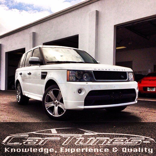 White Range Rover Sport parked in front of a building with the Car Tunes logo on the pavement.