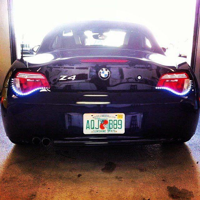 Rear view of a dark blue BMW Z4 with Florida license plate, parked in a garage.