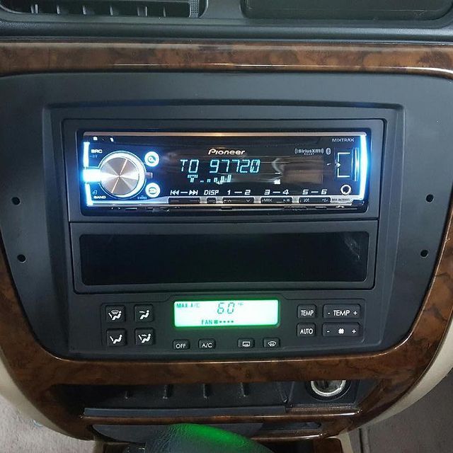 Dashboard with Pioneer car stereo, climate controls, and wood trim. The stereo displays Arabic text.