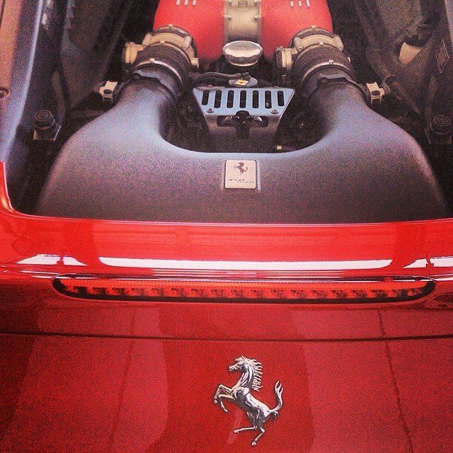 Red Ferrari engine with the iconic horse logo on the hood.