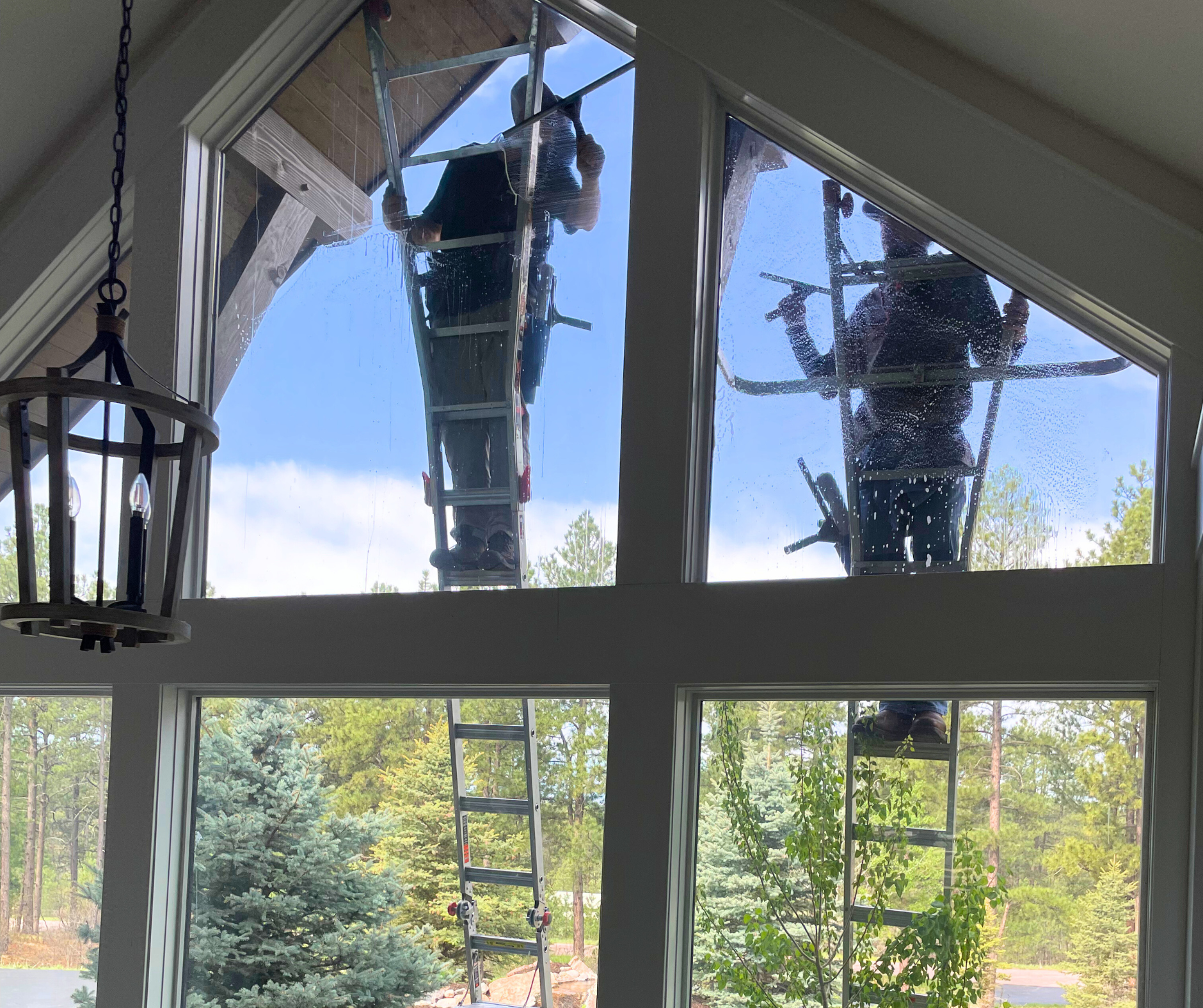 A man is cleaning the windows of a tall building.