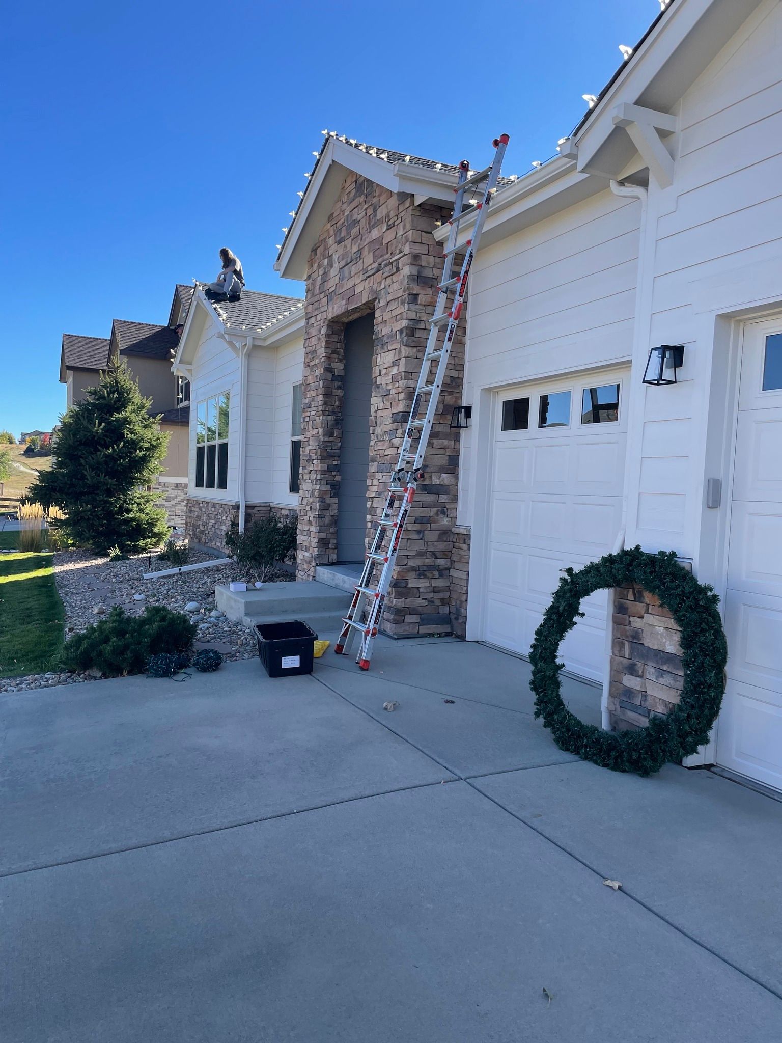 A house with a ladder and a wreath in front of it
