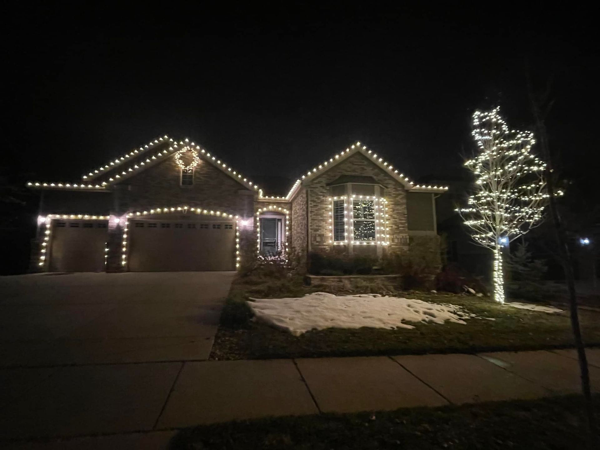 A house is decorated with christmas lights at night.