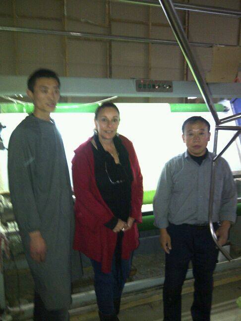 Three people standing next to each other in front of a machine