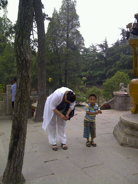 A woman kneeling down next to a little boy