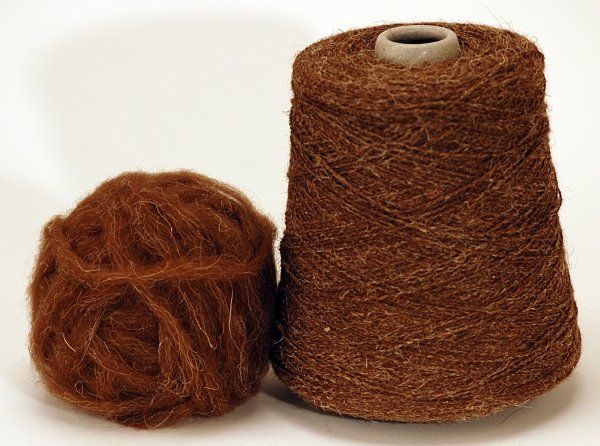 Two spools of brown yarn are sitting next to each other on a white surface.