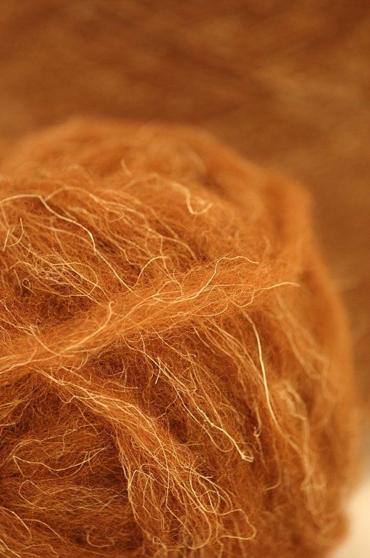 A close up of a ball of brown yarn on a table.