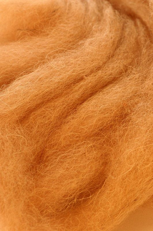 A close up of a piece of brown wool on a white surface.