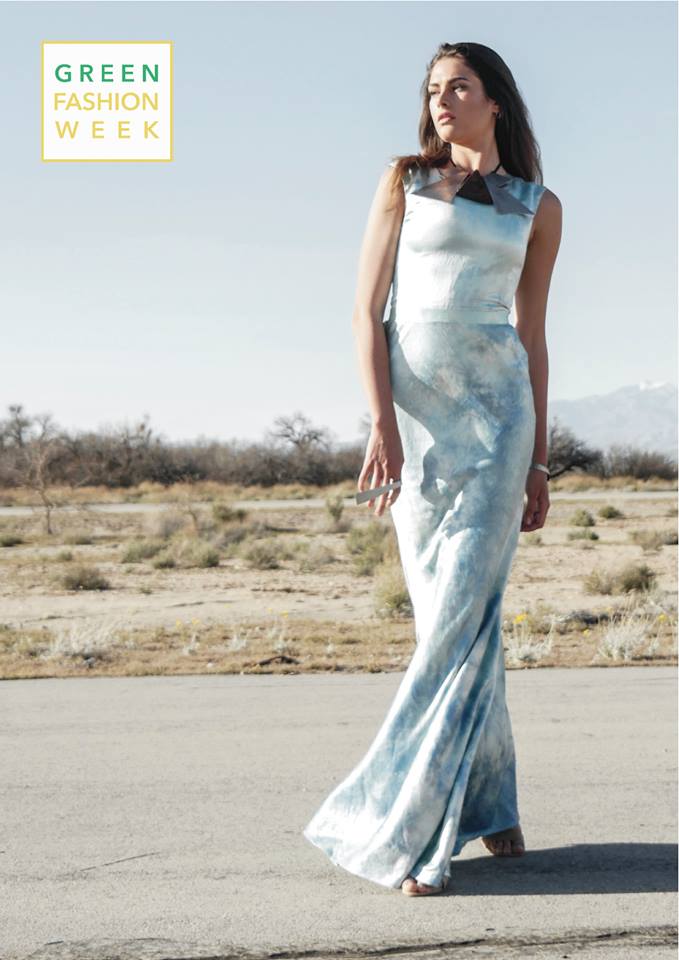 A woman in a blue tie dye dress is walking down a road