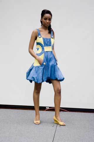 A woman in a blue and yellow dress is standing on a stage.