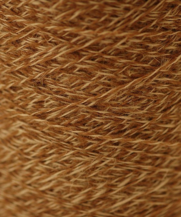 A close up of a spool of brown yarn.