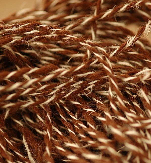 A close up of a ball of brown and white yarn.