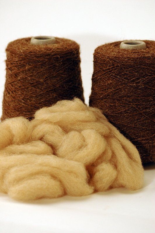 Two spools of yarn are sitting next to each other on a table.