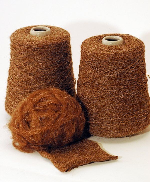 Three spools of brown yarn on a white surface