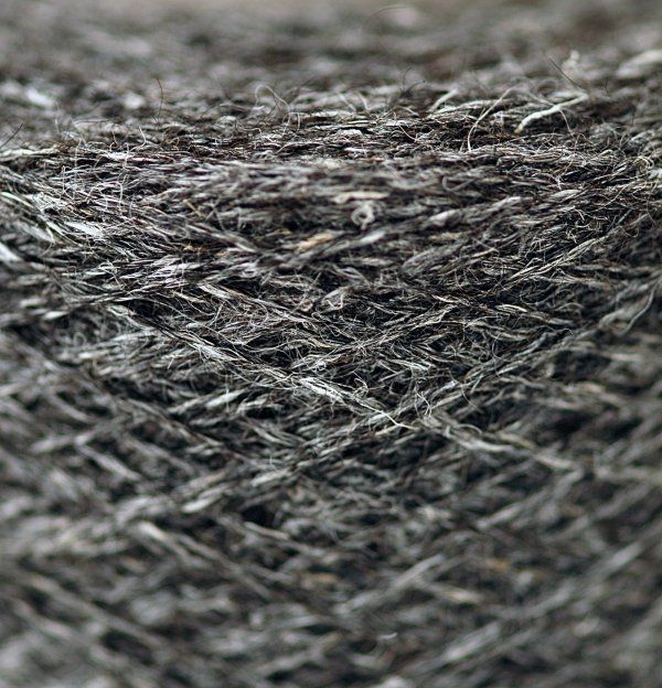 A close up of a spool of gray yarn.