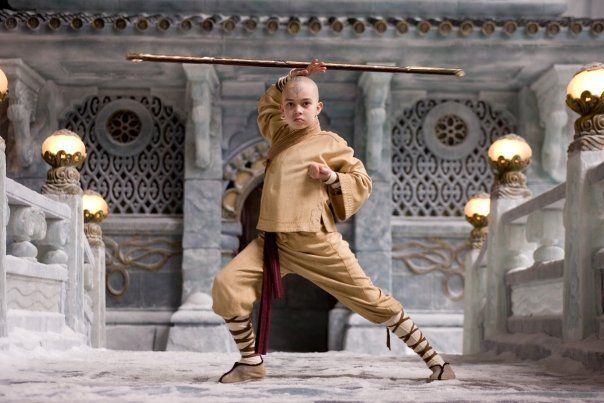 A bald man is holding a stick in a temple