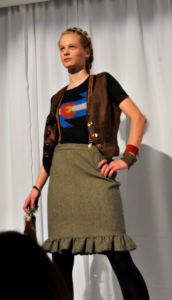 A woman wearing a brown vest and a green skirt