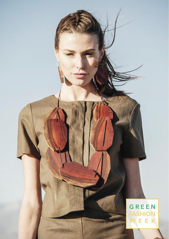 A woman wearing a necklace and earrings is standing in the desert.