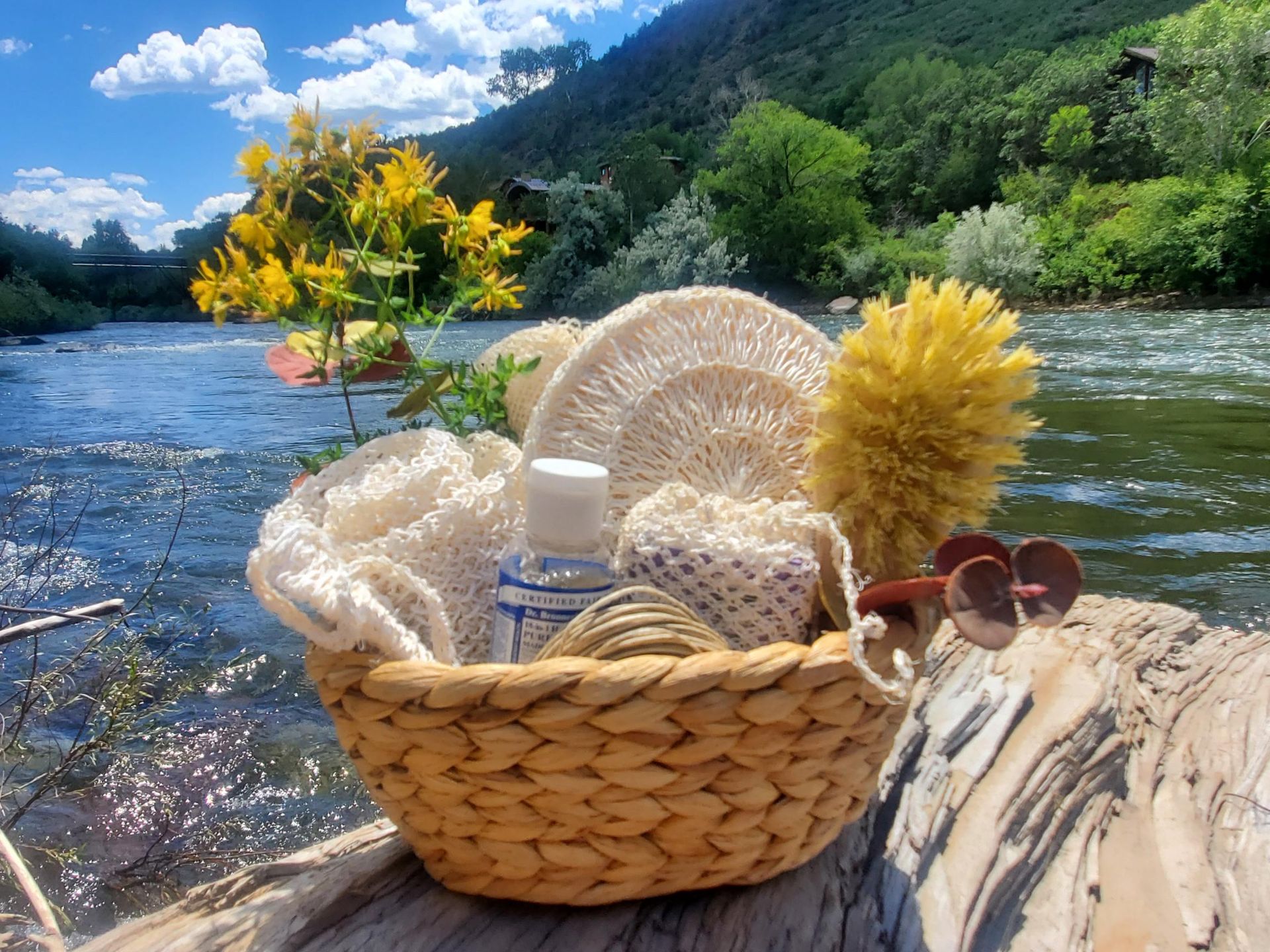 A wicker basket is sitting on a rock near a river.