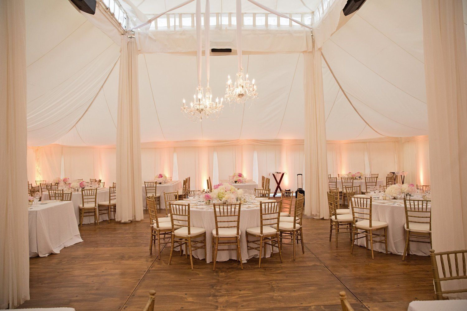 A large room with tables and chairs set up for a wedding reception.