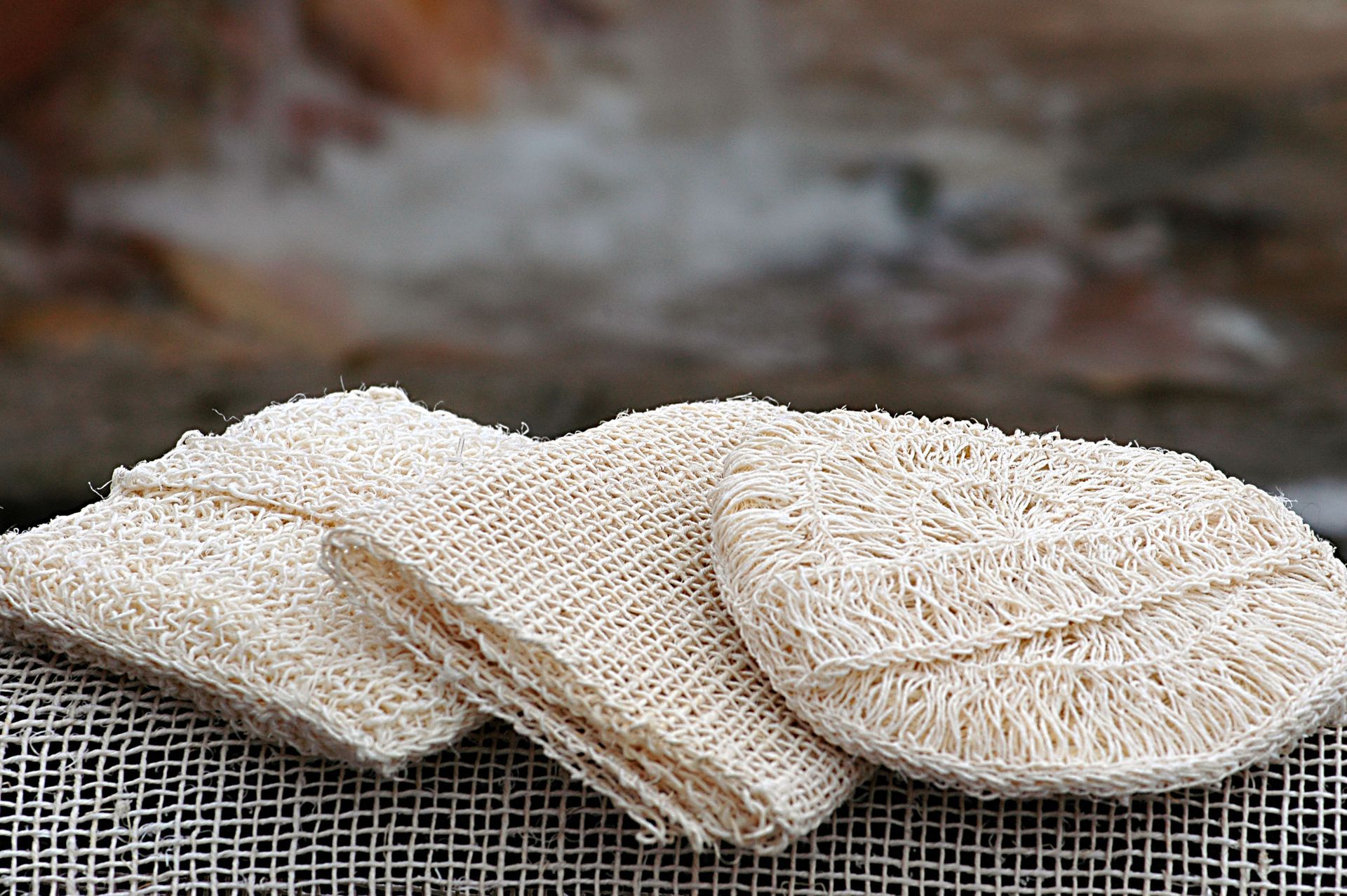 Three sponges are sitting on top of each other on a table.