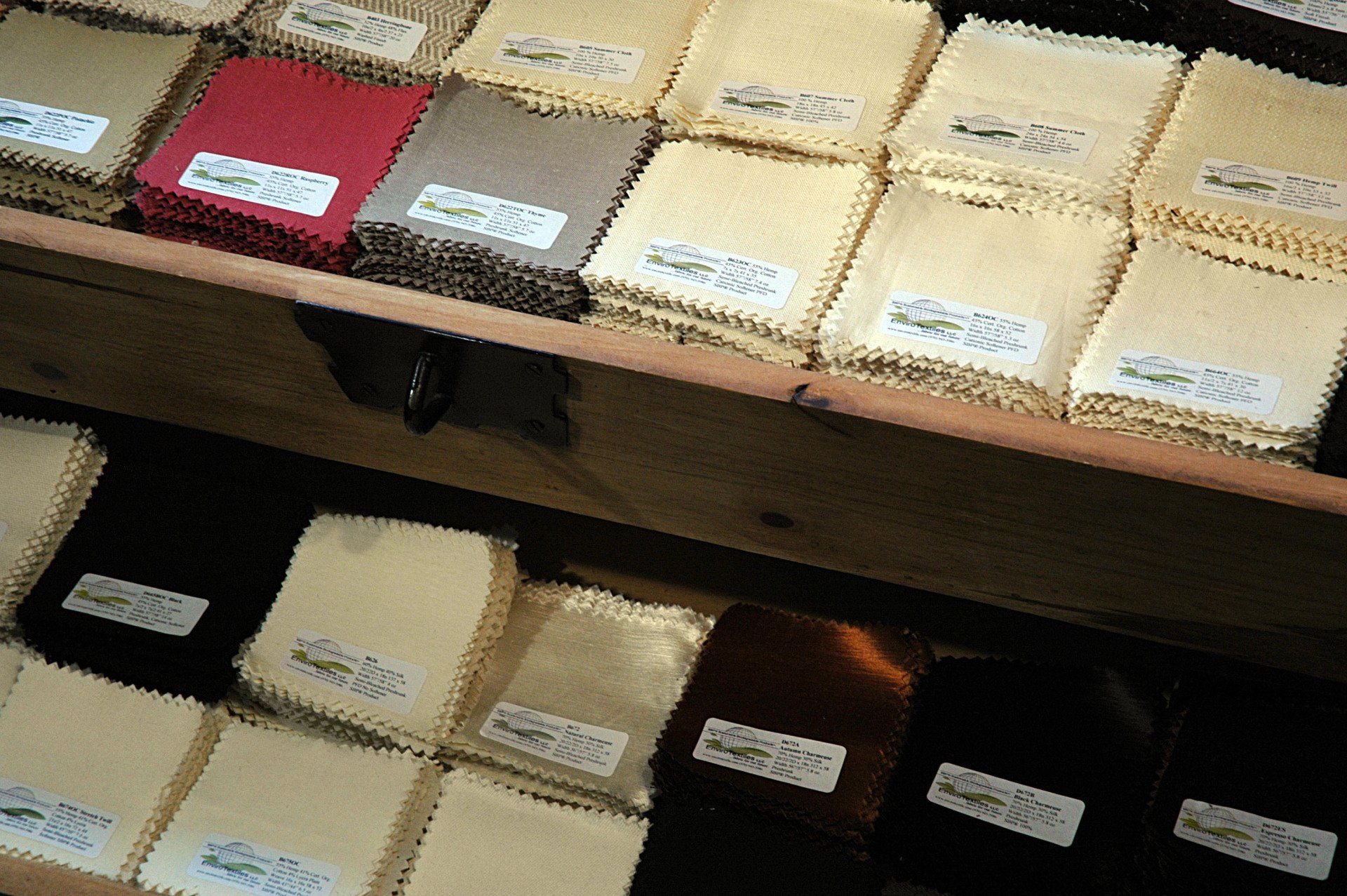 A wooden shelf filled with lots of different colored fabrics