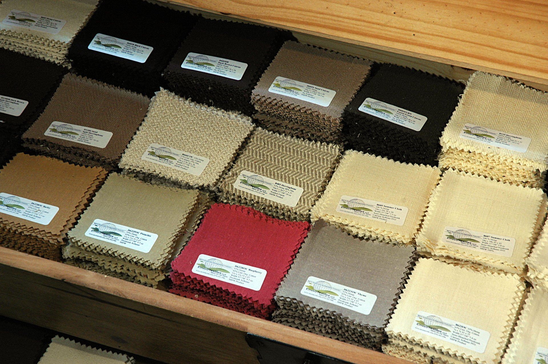 A wooden shelf filled with lots of different colored fabrics