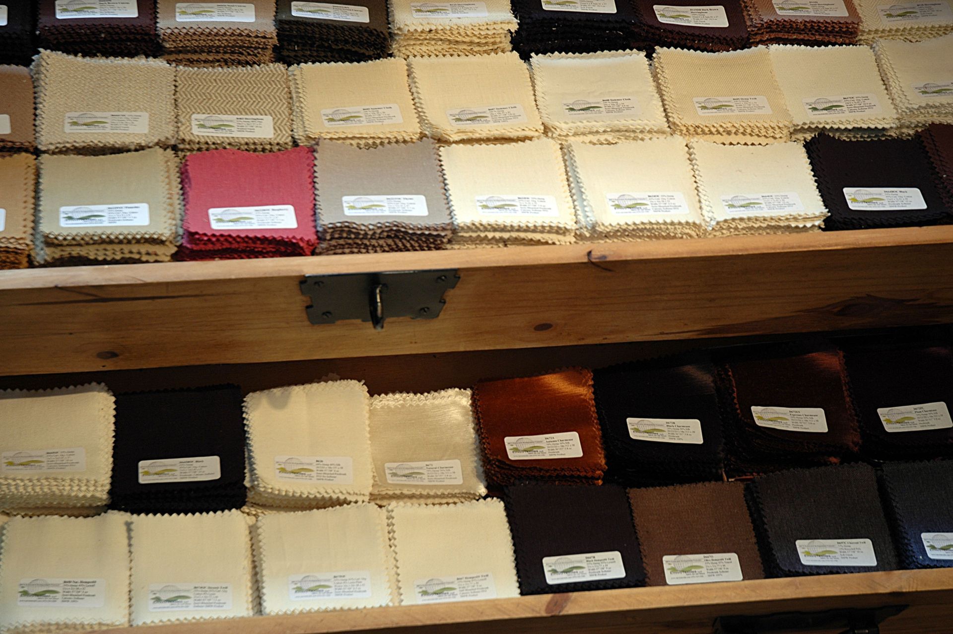 A wooden shelf filled with lots of different colored fabrics