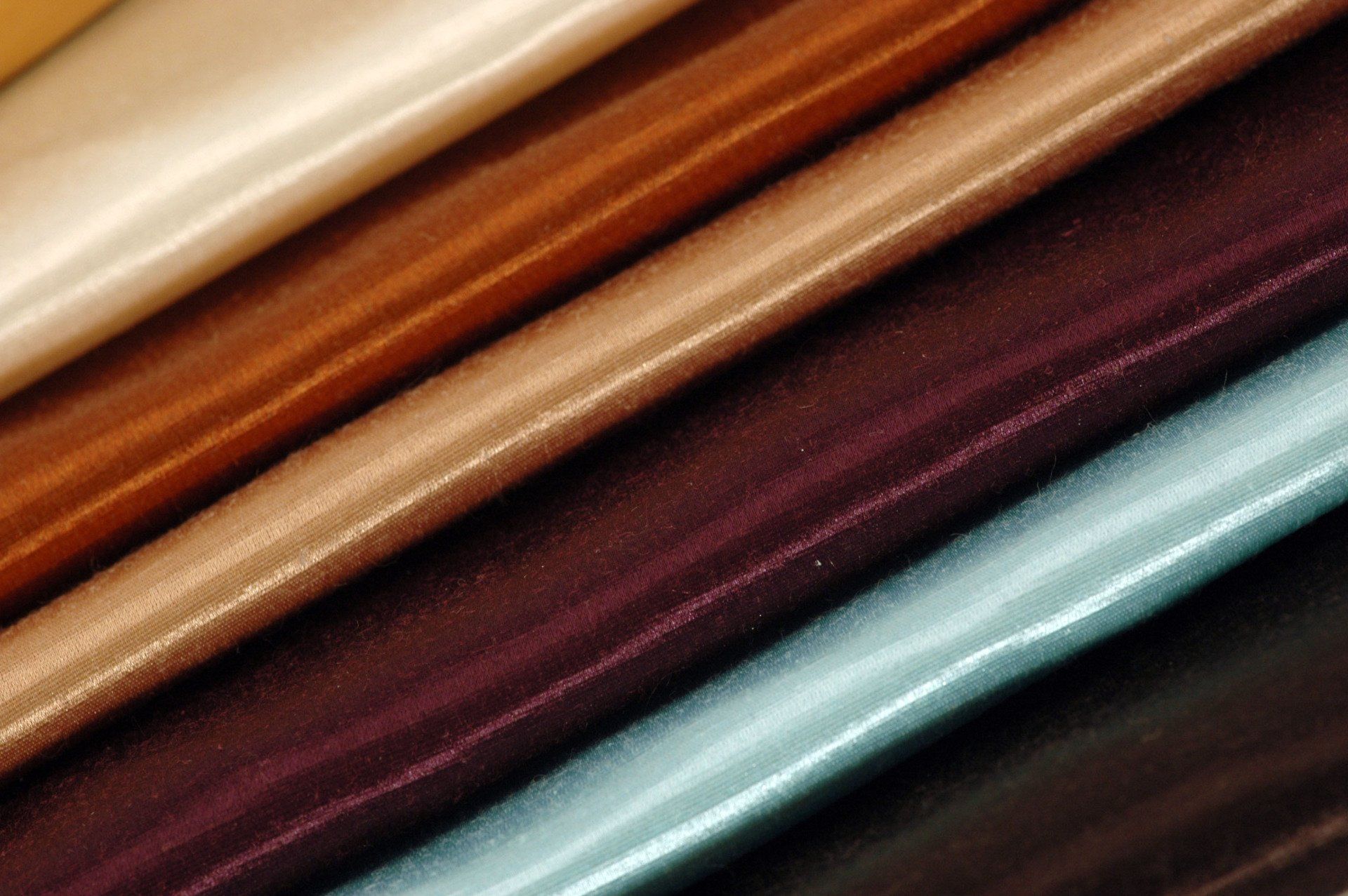 A close up of a stack of different colored fabrics.