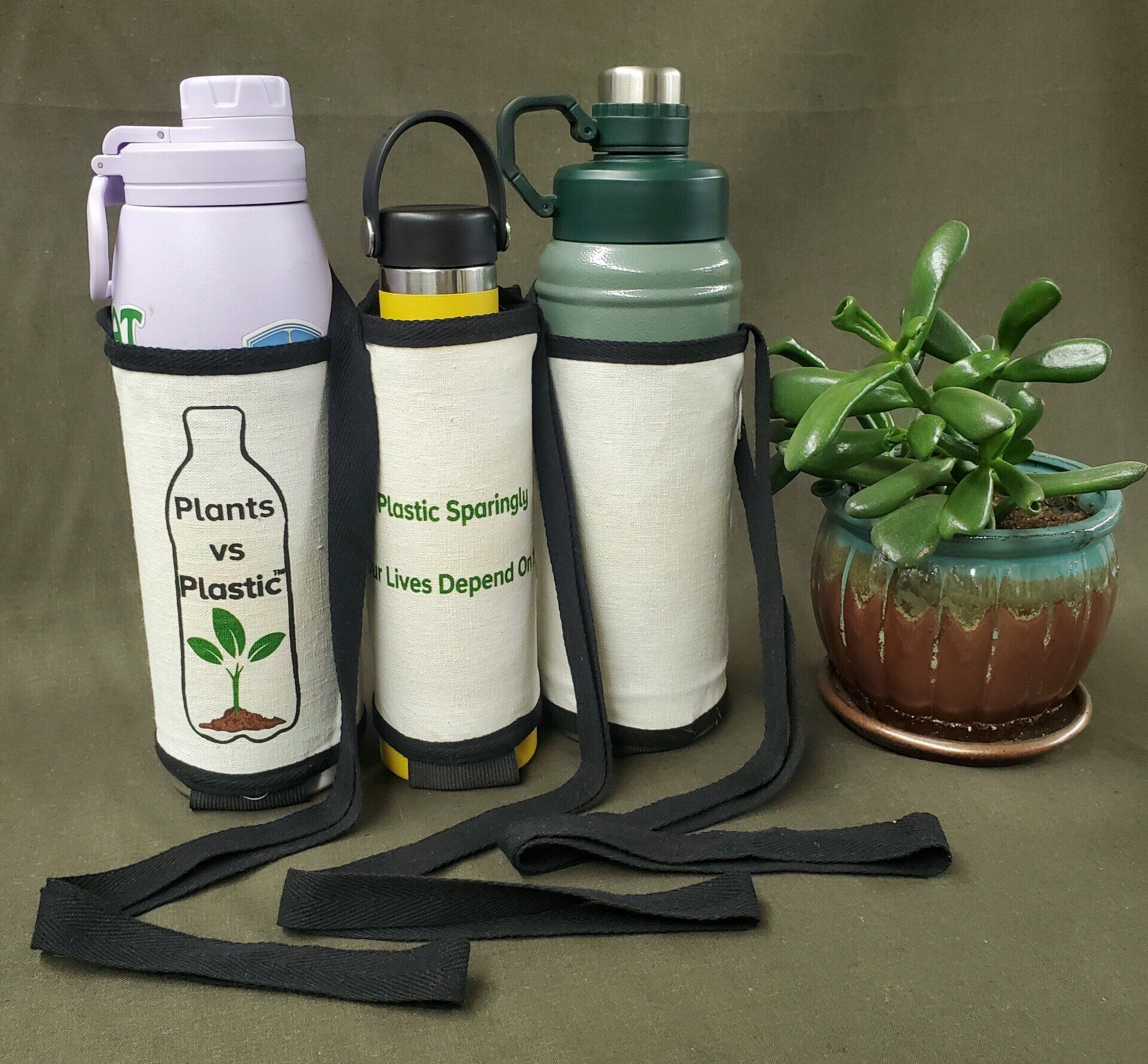 Three water bottles with plants vs plastic written on them