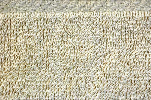 A close up of a white knitted fabric with a pattern.