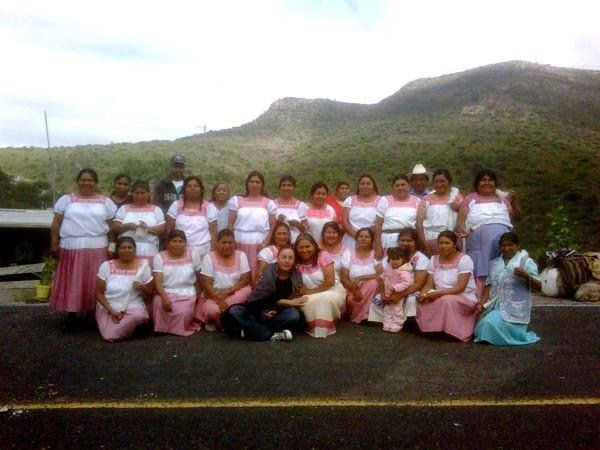 A group of women posing for a picture with mountains in the background