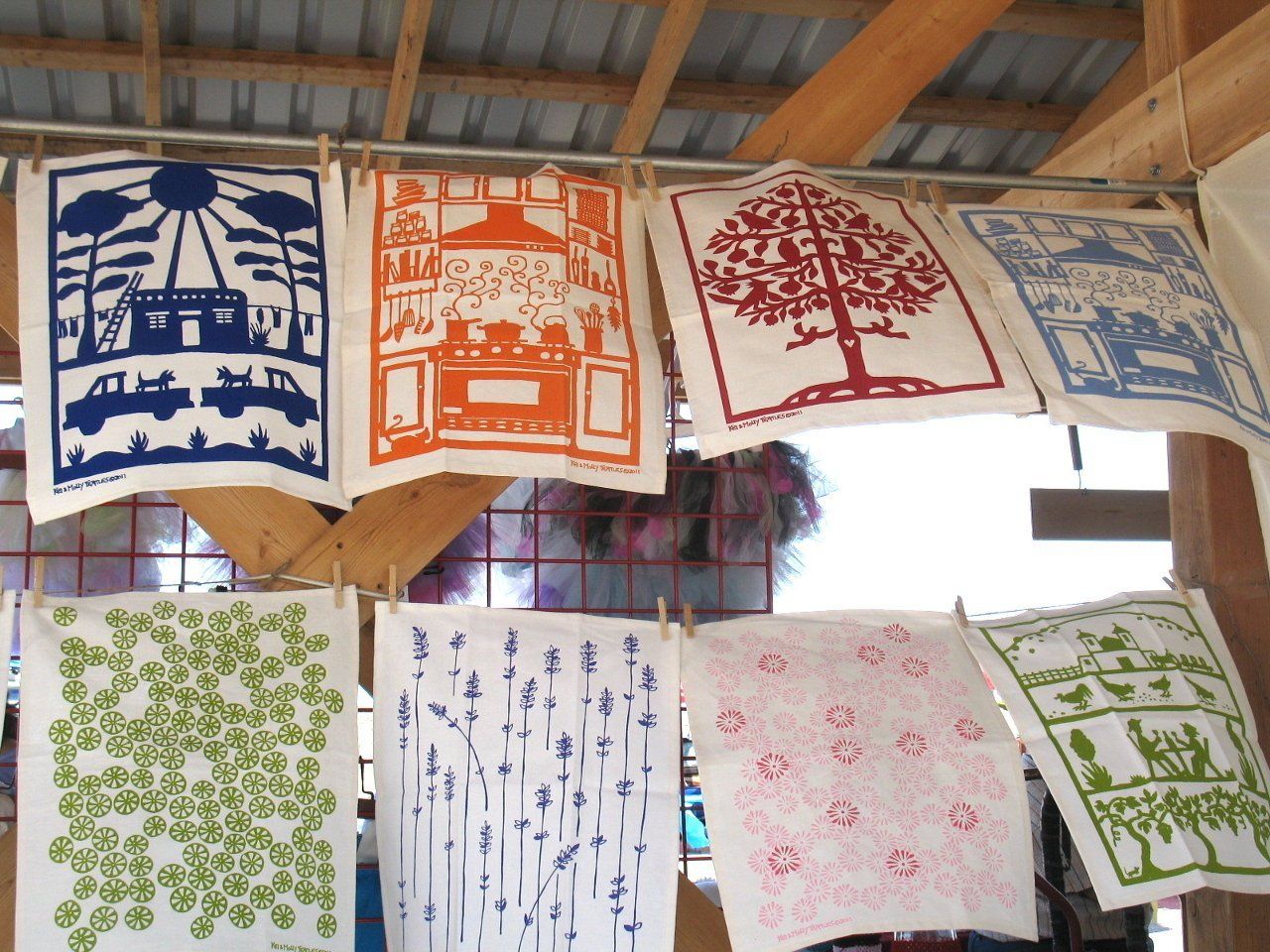 A bunch of papers hanging on a clothes line with different designs on them