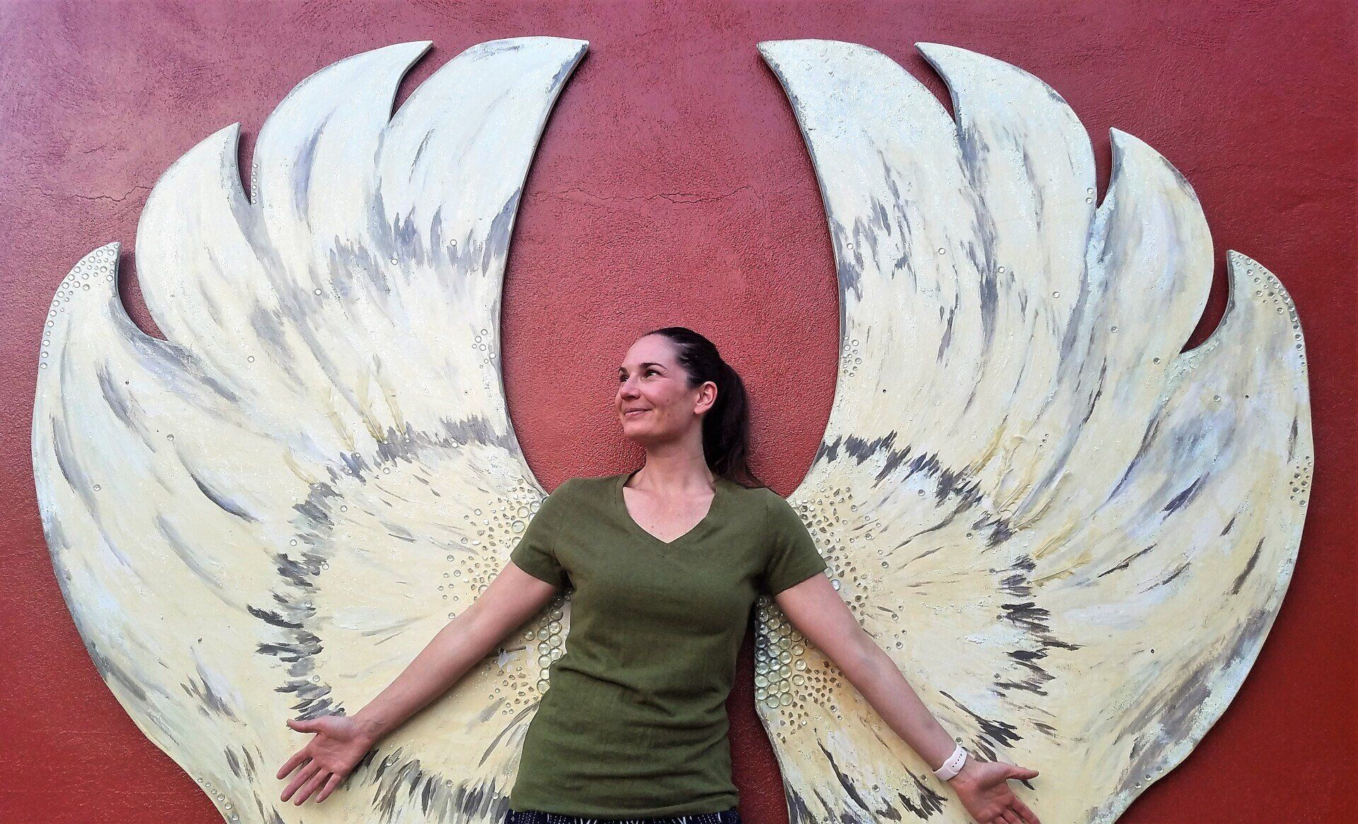 lady posing with wings wearing a green olive color EnviroTextiles Women's organic Hemp fabric T-shirt 