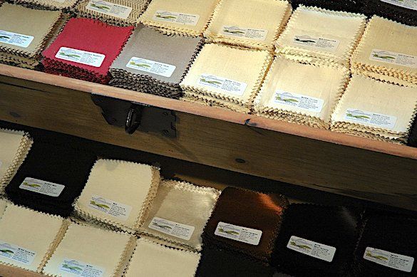 A wooden shelf filled with lots of different colored fabrics