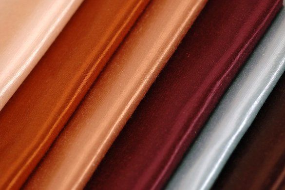 A close up of a stack of different colored leather sheets.