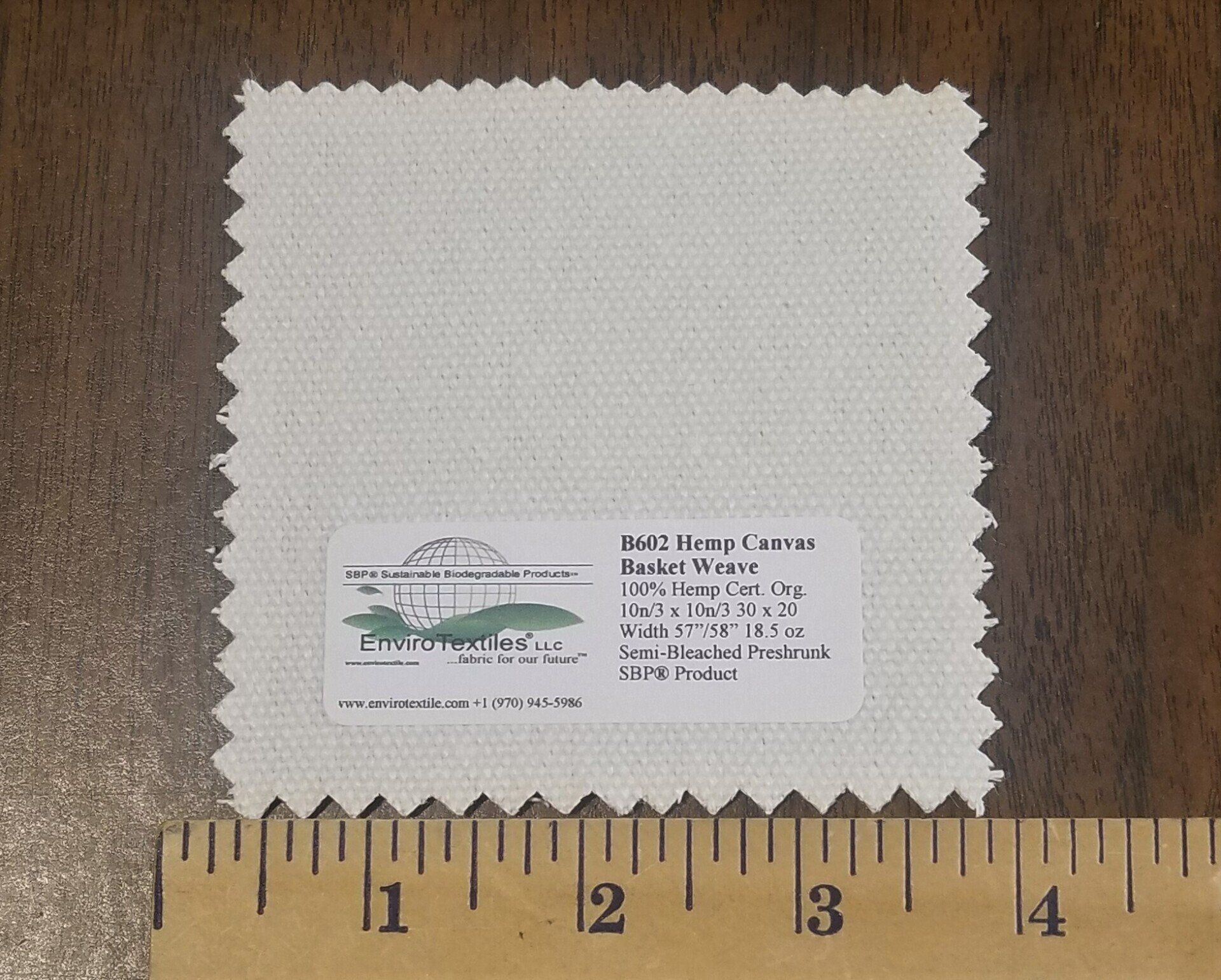 A piece of white fabric is being measured by a ruler