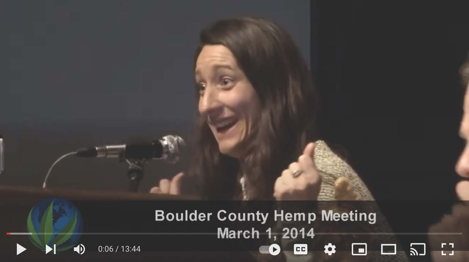 A woman is giving a thumbs up at a boulder county hemp meeting