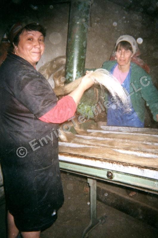 Two women are working in a factory and one of them is smiling
