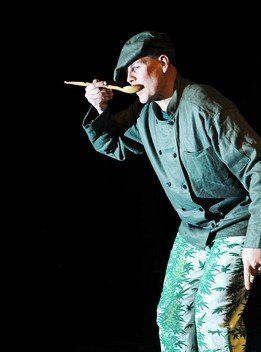 A man is holding a wooden spoon in his mouth.