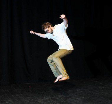 A man in a white shirt is jumping in the air