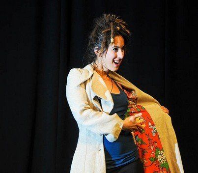 A woman with dreadlocks is wearing a trench coat