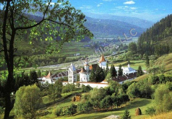 There is a church in the middle of a valley surrounded by trees.