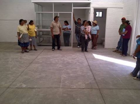 A group of people are standing in an empty room