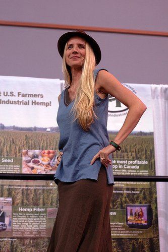 A woman is standing in front of a sign that says u.s. farmers industrial hemp