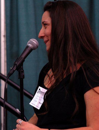 A woman speaking into a microphone with a name tag that says ' brooklyn ' on it